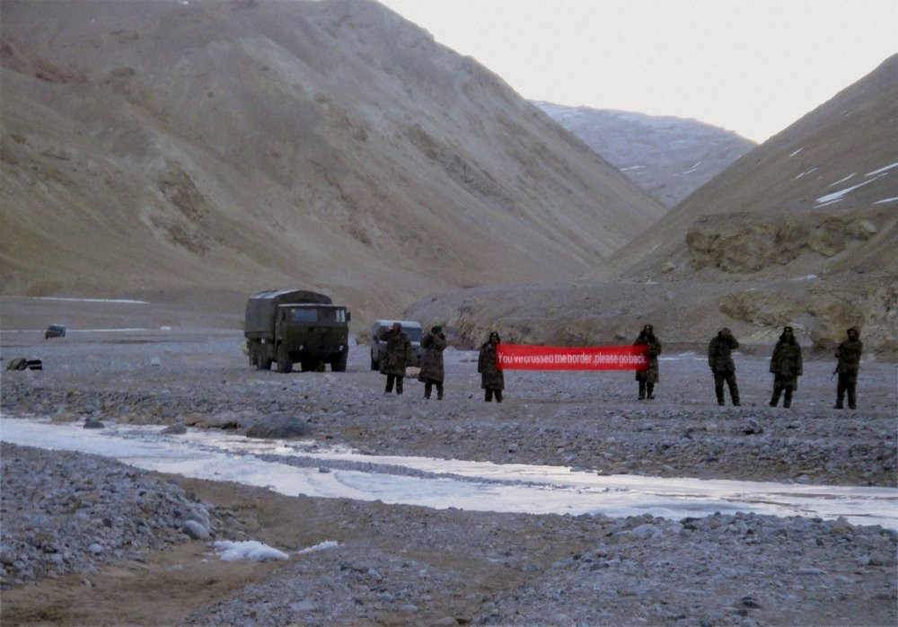In this May 5, 2013, file photo, Chinese troop hold a banner which reads: "You've crossed the border, please go back," in Ladakh, India.