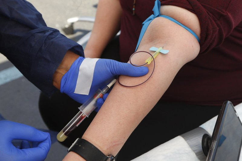 In this Friday, June 12, 2020 file photo, a woman has blood drawn for COVID-19 antibody testing in Dearborn, Michigan.
