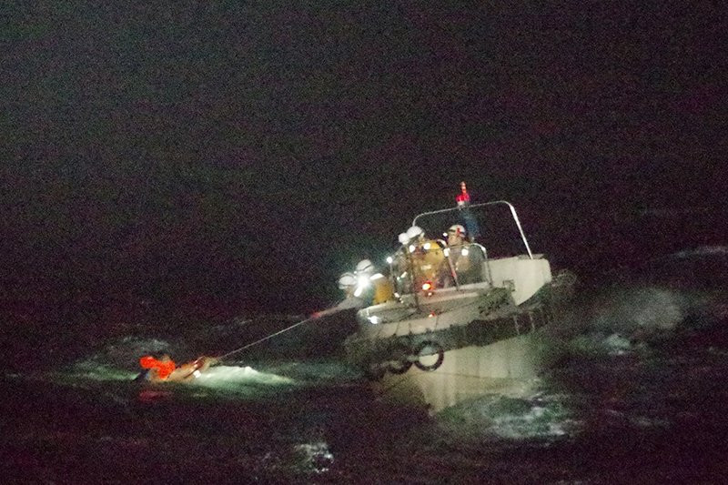 In this photo released by the 10th Regional Japan Coast Guard Headquarters, a Filipino crewmember of a Panamanian cargo ship is rescued by Japanese Coast Guard members in the waters off the A