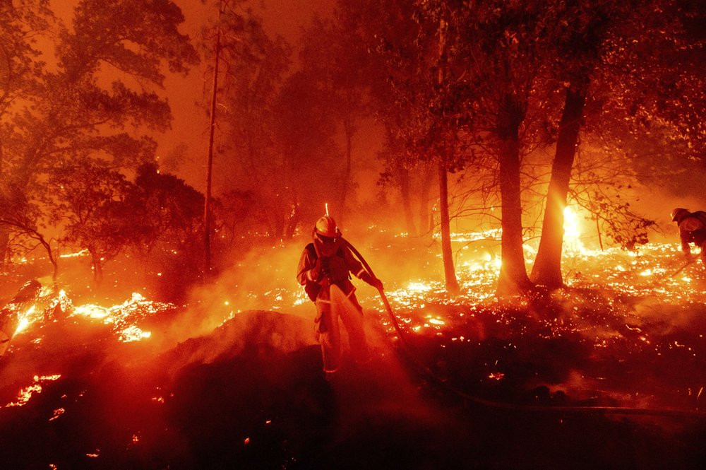 A firefighter battles the Creek Fire as it threatens homes in the Cascadel Woods neighborhood of Madera County, Calif., on Monday, Sept. 7, 2020.
