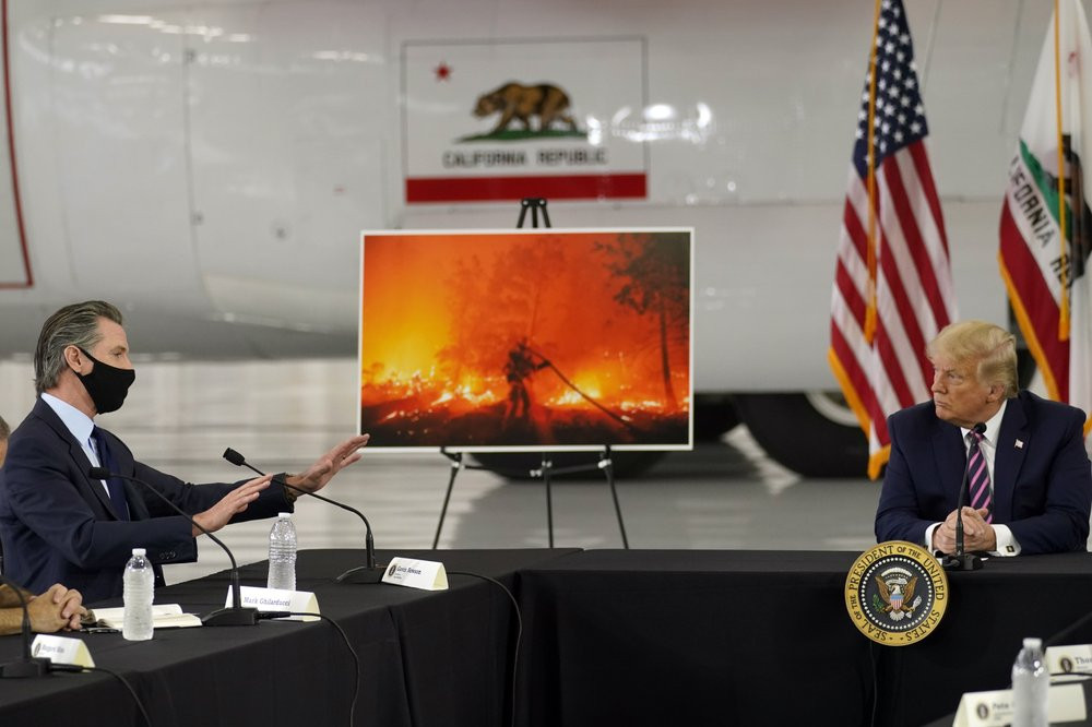 President Donald Trump listens as California Gov. Gavin Newsom speaks during a briefing at Sacramento McClellan Airport, in McClellan Park, Calif., Monday, Sept. 14, 2020, on the western wild