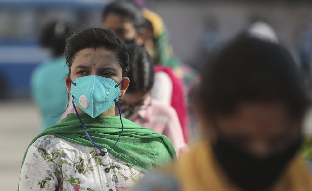 People wait in a queue to register their names to have their nasal swab samples taken to test for COVID-19 at a government hospital in Jammu, India, Tuesday, Sept. 15, 2020.
