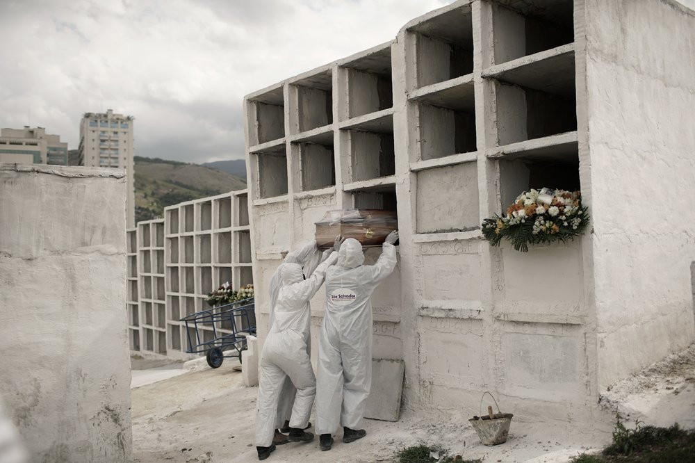 In this Sept. 24, 2020, file photo, cemetery workers place the coffin containing the remains of Jose de Arimateia, 65, who died from COVID-19 complications, into a niche at the municipal ceme