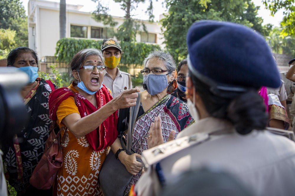 An Indian activist argues with a police officer before being detained by police during a protest in New Delhi, India, Wednesday, Sept. 30, 2020.