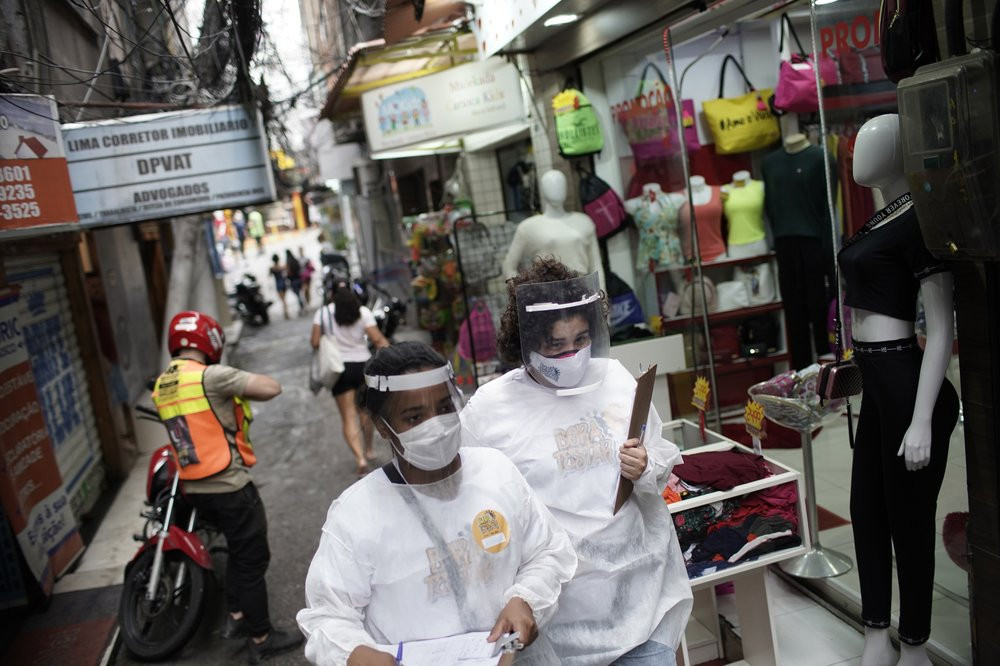 Health workers walk through the Rocinha slum to test people for COVID-19 as part of a rapid test campaign by the civilian organization "Bora Testar," or "Let's Test" in Rio de Janeiro, Brazil