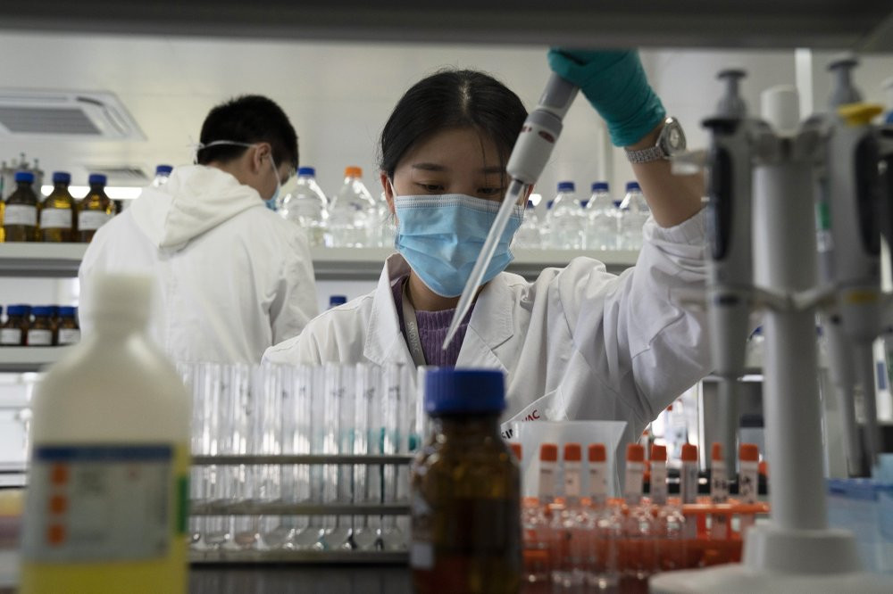 In this Sept. 24, 2020, file photo, an employee of SinoVac works in a lab at a factory producing its SARS-CoV-2 vaccine for COVID-19 named CoronaVac in Beijing.