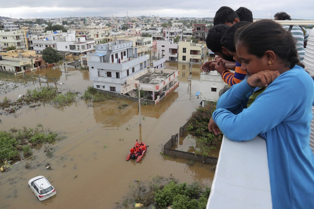 Residents look at a street inundated with floodwater after heavy rainfall in Hyderabad, India, India, Wednesday, Oct. 14, 2020.