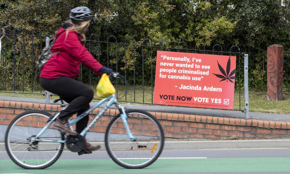 A cyclist rides past a sign in support of making marijuana legal in Christchurch, New Zealand, Thursday, Oct. 15, 2020.