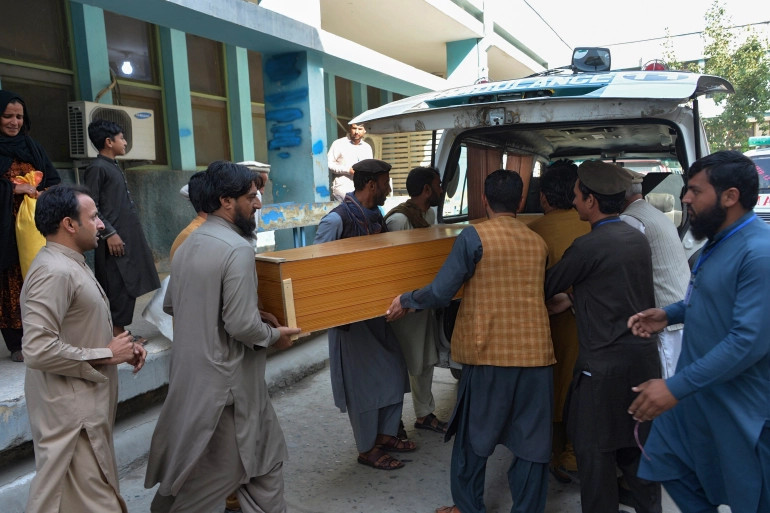 Relatives carry the coffin of a victim killed in the stampede, outside a mortuary in Jalalabad.