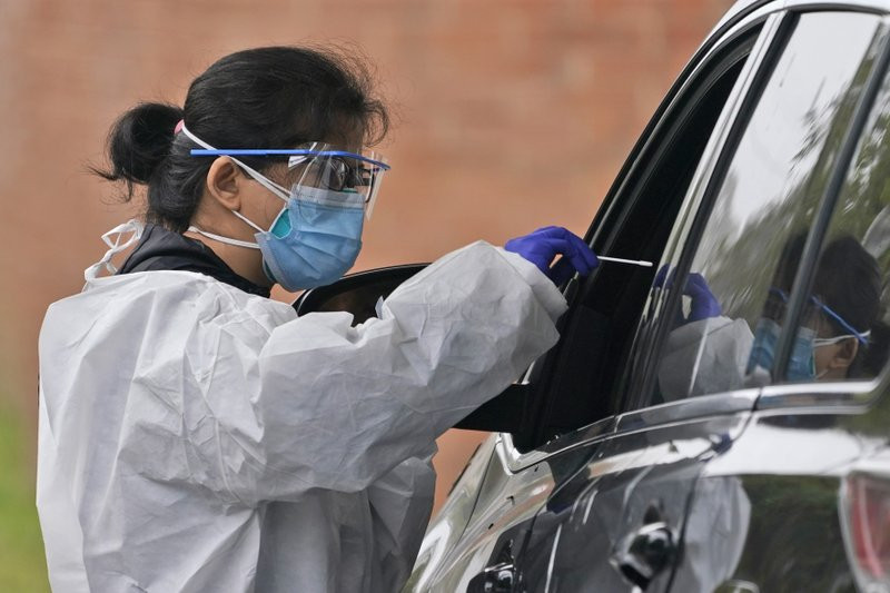 Medical personnel prepare to administer a COVID-19 swab at a drive-through testing site in Lawrence, N.Y., Wednesday, Oct. 21, 2020.
