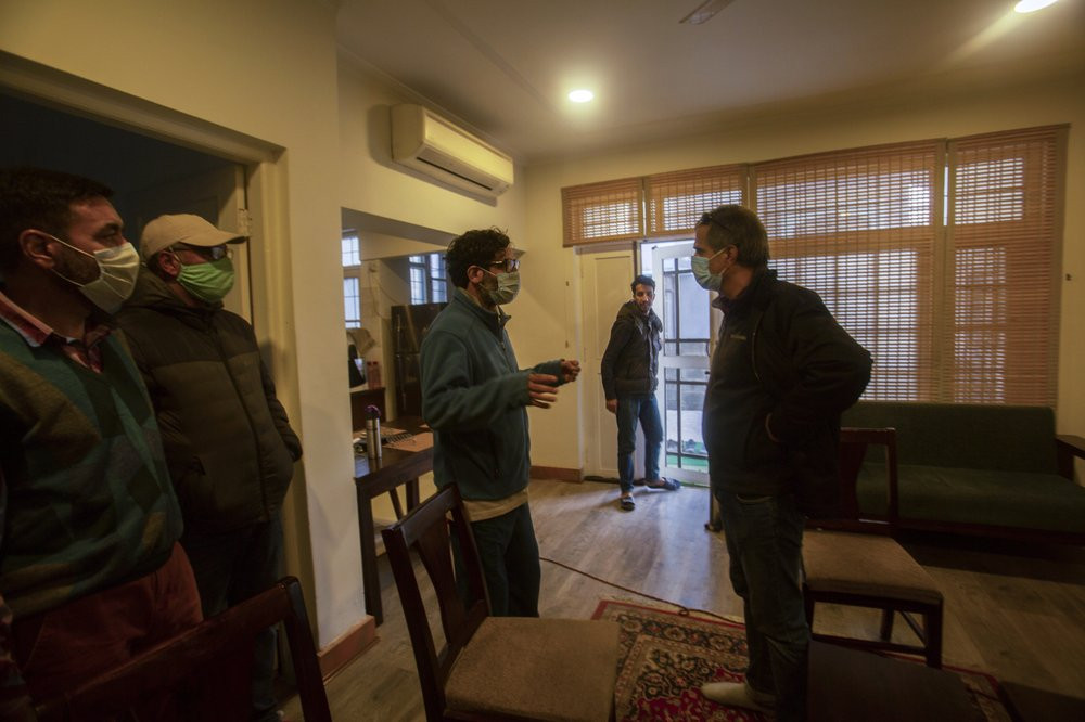 Agence France-Presse’s Kashmir correspondent Parvaiz Bukhari, centre, talks to his colleagues after National Investigation Agency personnel searched his premises on the outskirts of Srinagar,