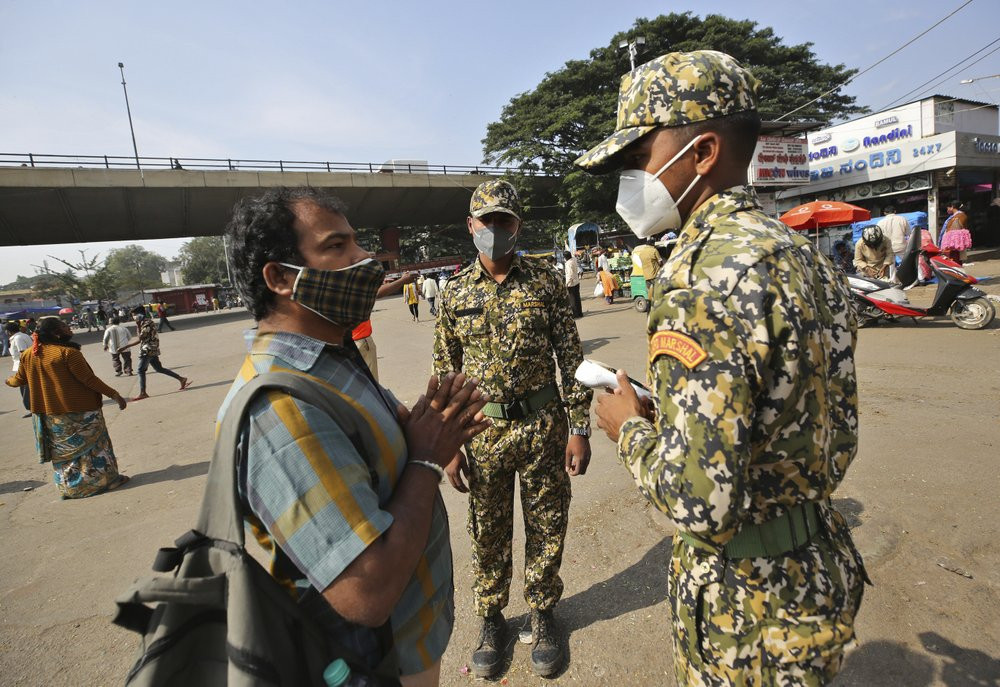 A man pleads with municipal officers as he is fined for not wearing a face mask in Bengaluru, India, Thursday, Oct. 29, 2020.