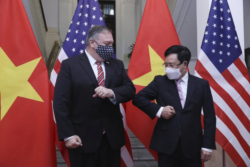 U.S. Secretary of State Mike Pompeo, left, and Vietnamese Foreign Minister Pham Binh Minh gesture with their elbows before a meeting in Hanoi, Vietnam, Friday, Oct. 30, 2020.