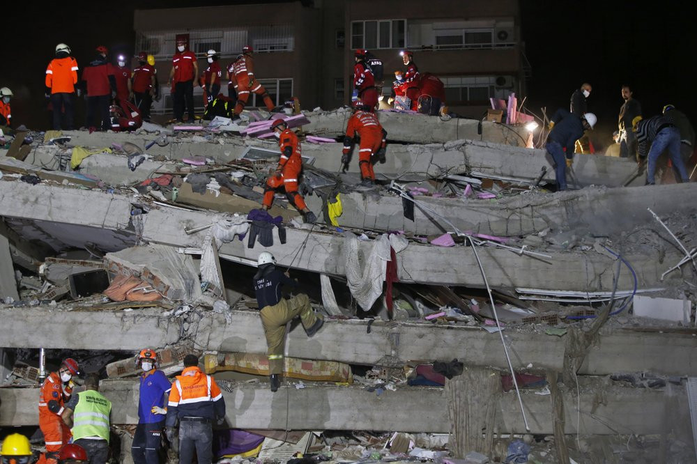 Members of rescue services search in the debris of a collapsed building for survivors in Izmir, Turkey, early Saturday, Oct. 31, 2020.