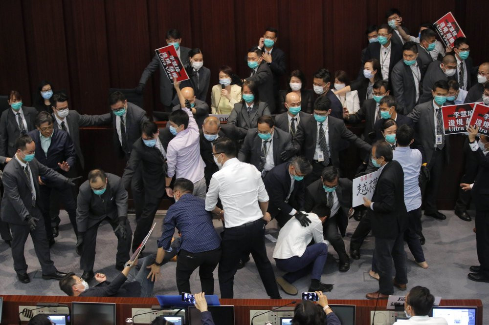 Pro-establishment politician, Starry Lee, center, speaks as pan-democratic legislators scuffle with security guards and pro-China legislators during a Legislative Council's House Committee me