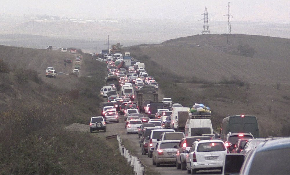 In this photo taken from the Associated Press Television video, people stuck in a traffic jam as they leave the separatist region of Nagorno-Karabakh to Armenia, Saturday, Nov. 7, 2020.