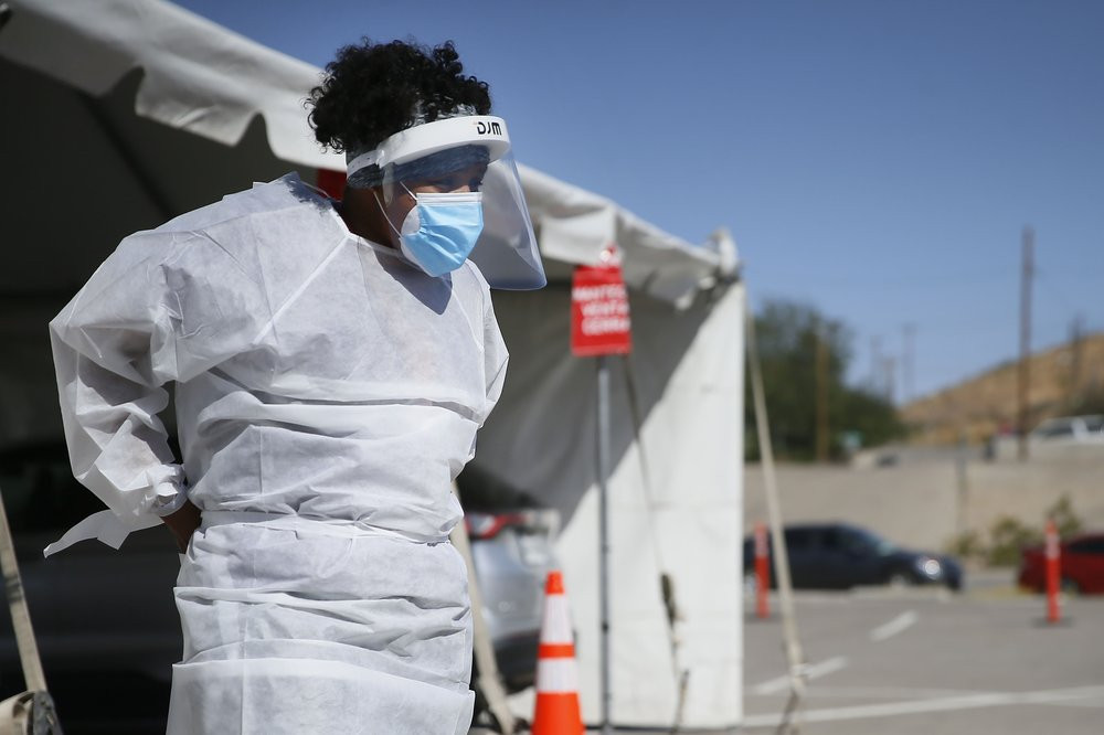 In this Oct. 26,2020, file photo, a medical worker stands at a COVID-19 state drive-thru testing site at UTEP, in El Paso, Texas.