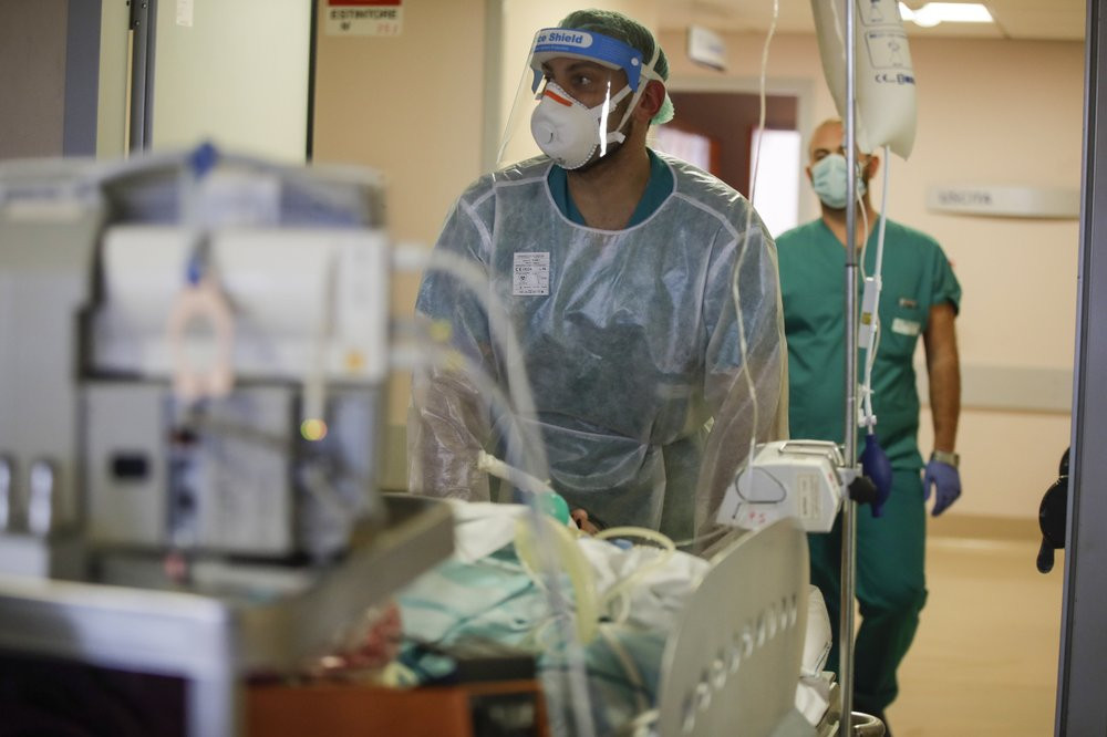 Doctors carry a coronavirus patient in the Intensive Care Unit at Varese’s Circolo hospital, in Varese, Italy, Friday, Nov. 6, 2020.