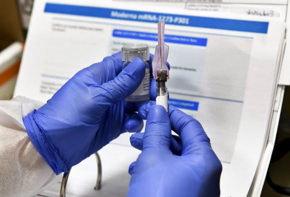In this July 27, 2020, file photo, nurse Kathe Olmstead prepares a shot that is part of a possible COVID-19 vaccine, developed by the National Institutes of Health and Moderna Inc., in Bingha