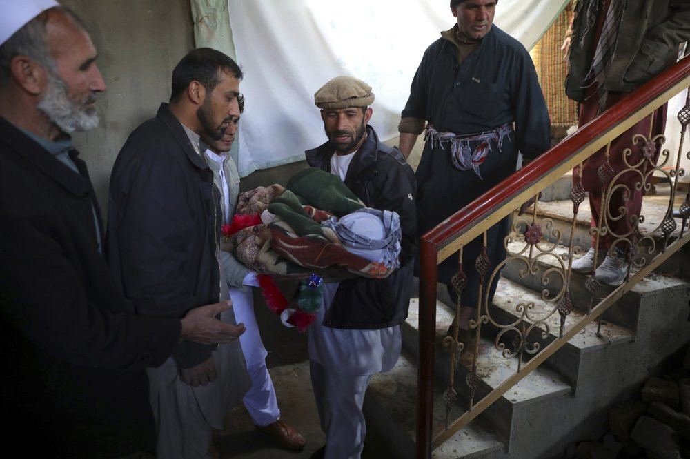 Relatives carry the dead body of a boy who was killed by a mortar shell attack in Kabul, Afghanistan, Saturday, Nov. 21, 2020. Mortar shells slammed into different parts of the Afghan capital