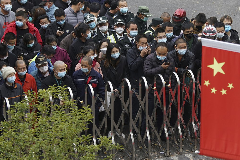 Airport workers wearing face masks to help curb the spread of the coronavirus wait for COVID-19 testing at the Shanghai Pudong International Airport in Shanghai, Monday, Nov. 23, 2020.