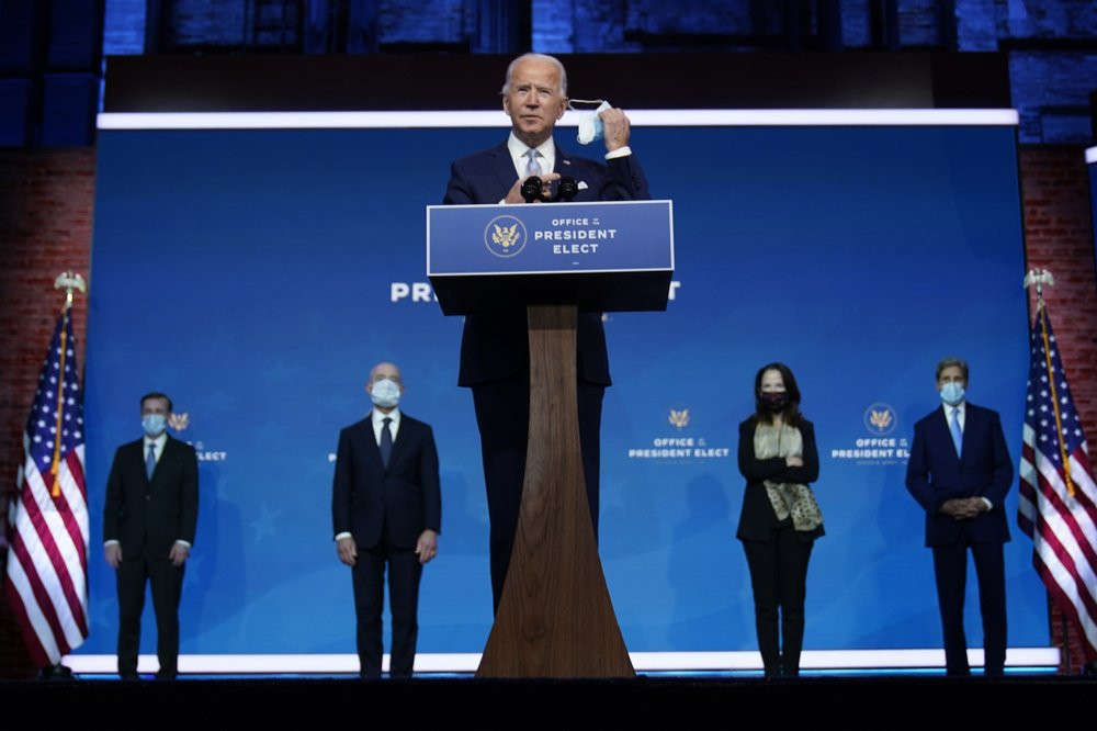 US President-elect Joe Biden removes his face mask as he arrives to introduce his nominees and appointees to key national security and foreign policy posts at The Queen theater, Tuesday, Nov.