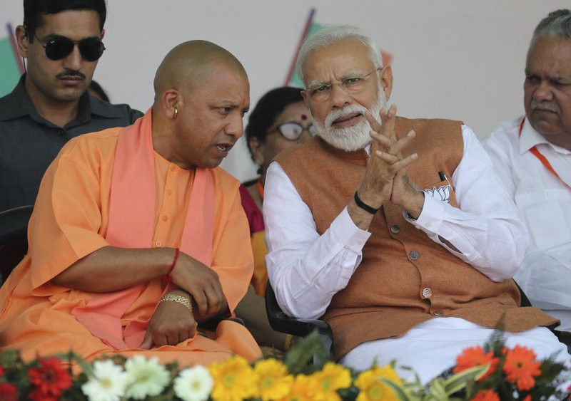 In this March 28, 2019, file photo, Indian Prime Minister Narendra Modi, right, speaks with Chief Minister of Uttar Pradesh state Yogi Adityanath during an election campaign rally in Meerut, 