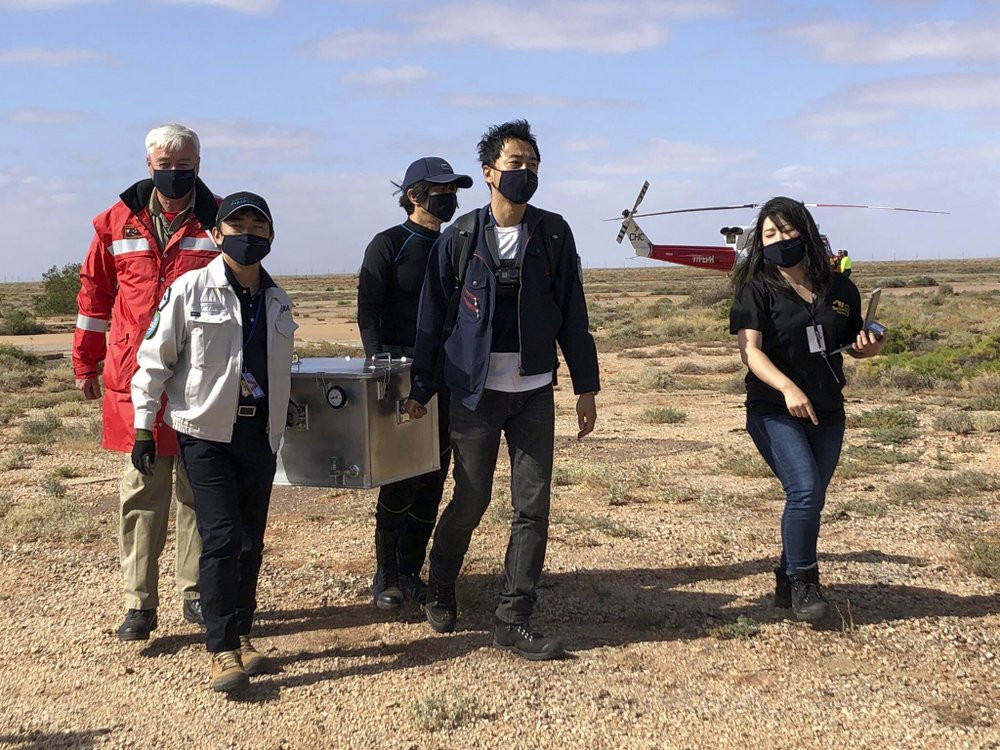 In this photo provided by the Australian Space Agency, members of the Japan Aerospace Exploration Agency (JAXA) arrive at a range support facility in Woomera, Australia, Sunday, Dec. 6, 2020,