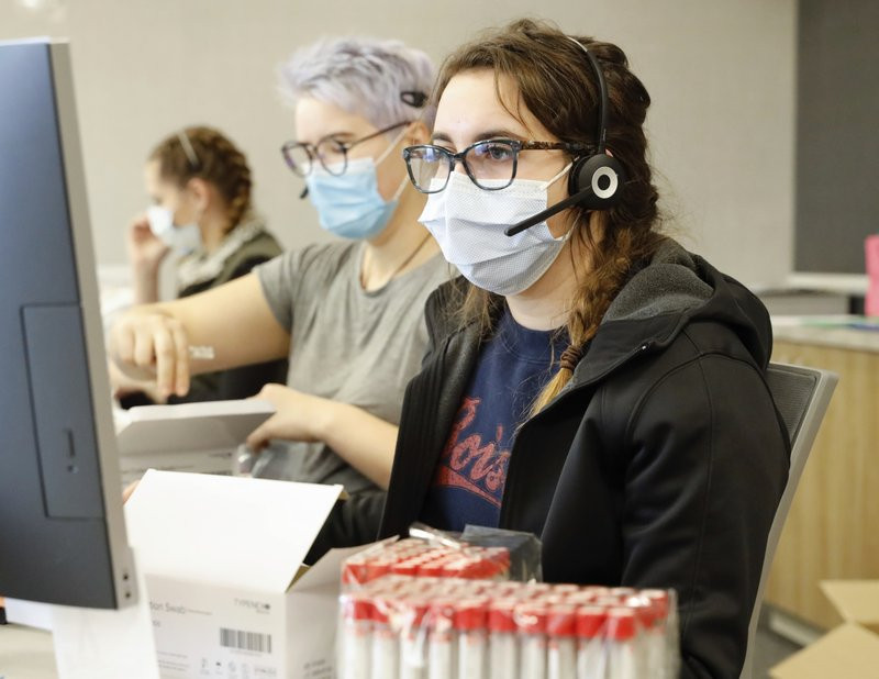 Employees schedule COVID-19 tests and prepare test kits at Primary Health Medical Group's clinic in Boise, Idaho, on Tuesday, Nov. 24, 2020.