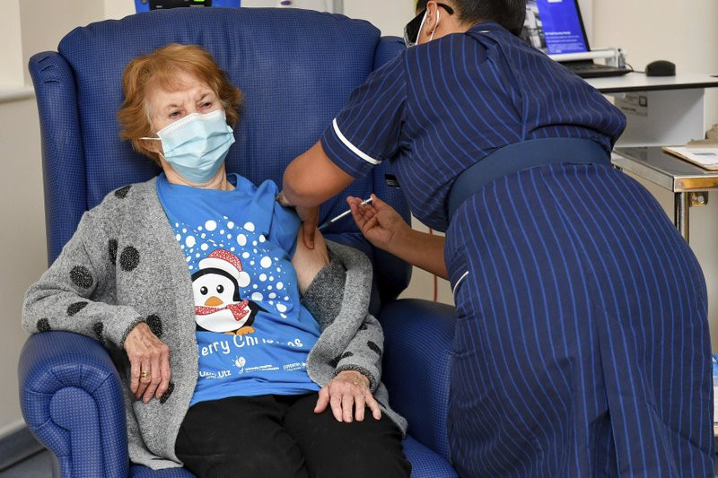 90 year old Margaret Keenan, the first patient in the UK to receive the Pfizer-BioNTech COVID-19 vaccine, administered by nurse May Parsons at University Hospital, Coventry, England, Tuesday 
