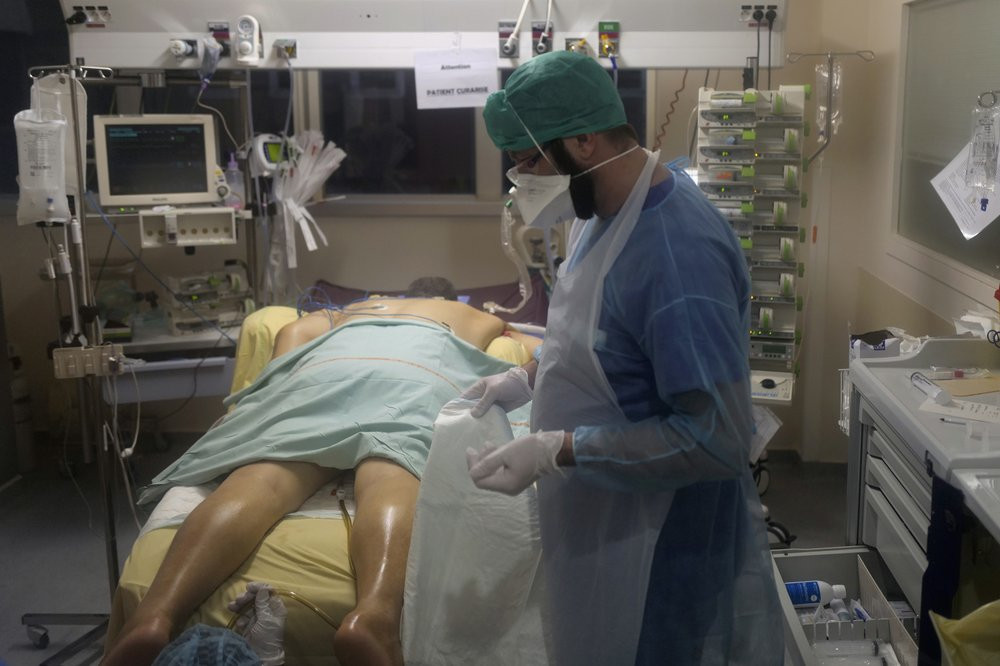 Paramedic Bertrand Brissaud, cares for the patient in room No. 10, a few hours before he died after his nearly month-long battle against COVID-19 at Bichat Hospital, AP-HP, in Paris Tuesday, 