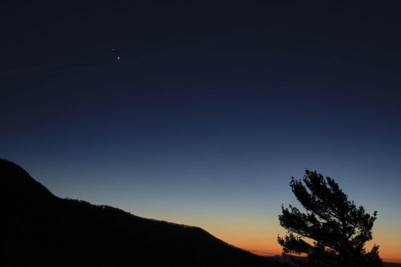 In this Sunday, Dec. 13, 2020 photo made available by NASA, Saturn, top, and Jupiter, below, are seen after sunset from Shenandoah National Park in Luray, Va.
