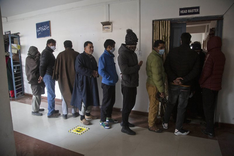 Kashmiris stand in a queue to cast their votes during the first phase of District Development Councils election on the outskirts of Srinagar, Indian controlled Kashmir, Saturday, Nov. 28, 202