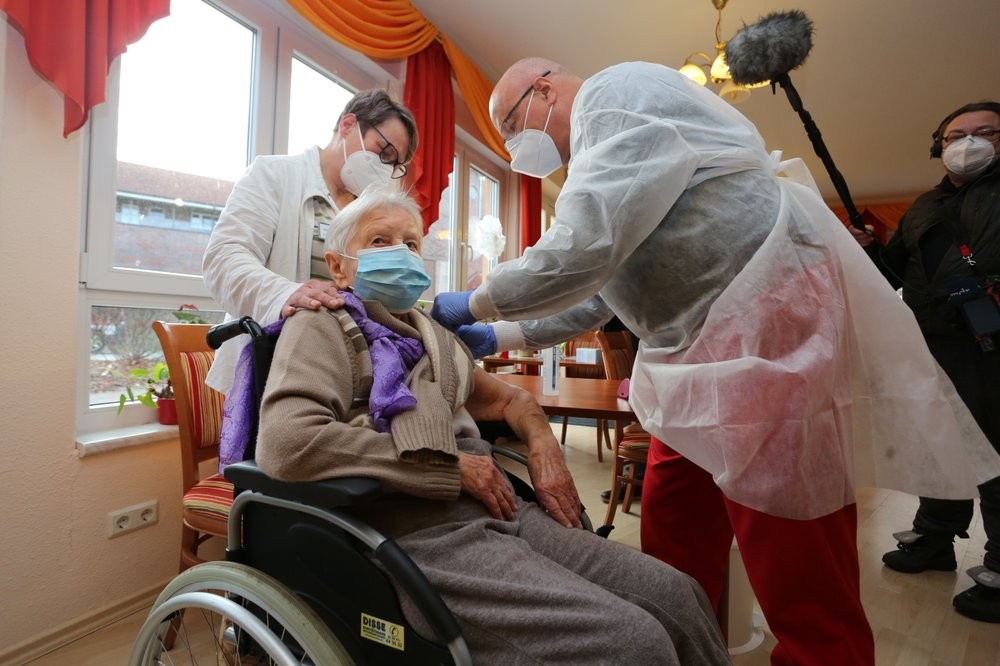Doctor Bernhard Ellendt, right, injects the COVID-19 vaccine to nursing home resident Edith Kwoizalla, 101 years old, in Halberstadt, Germany, Saturday, Dec. 26, 2020.