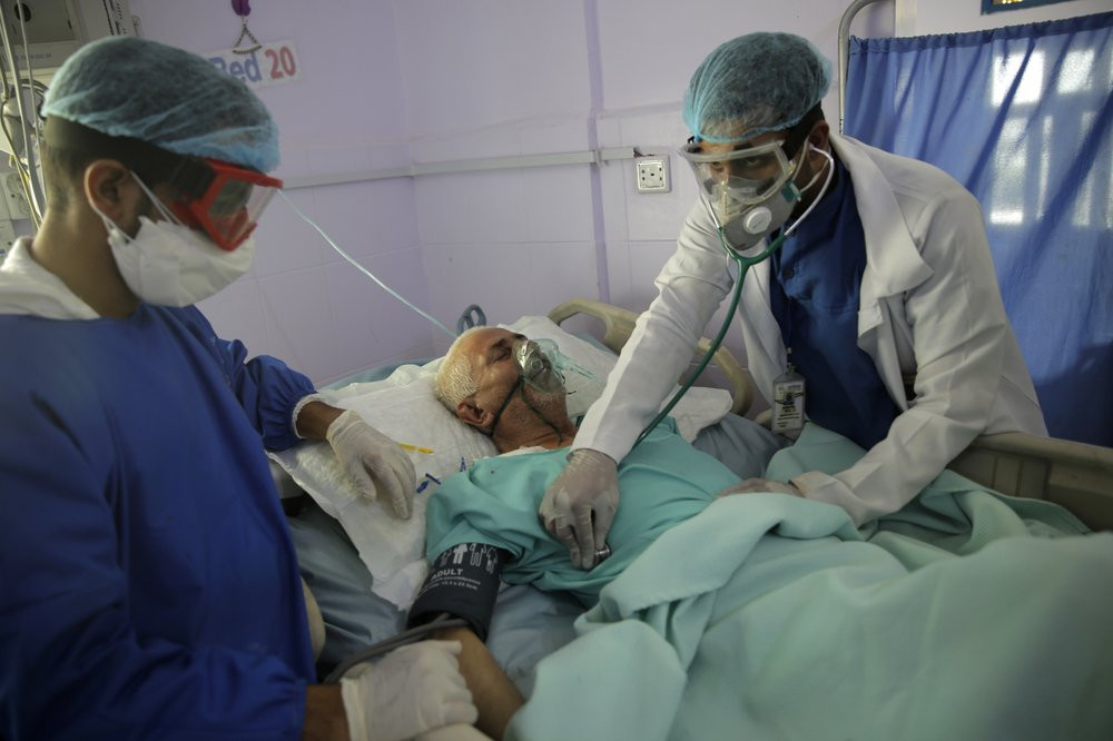 In this June 14, 2020, file photo, medical workers attend to a COVID-19 patient in an intensive care unit at a hospital in Sanaa, Yemen.