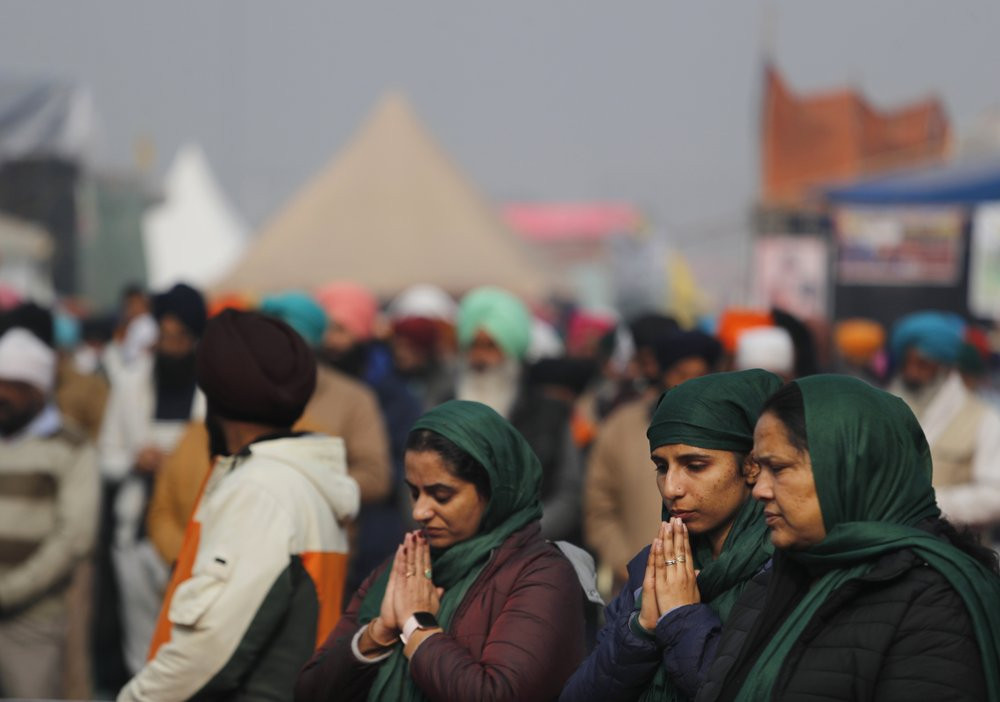 Women farmers pray during a gathering in protest against new farm laws at the Delhi-Haryana state border, on the outskirts of New Delhi, India, Sunday, Dec. 27, 2020.