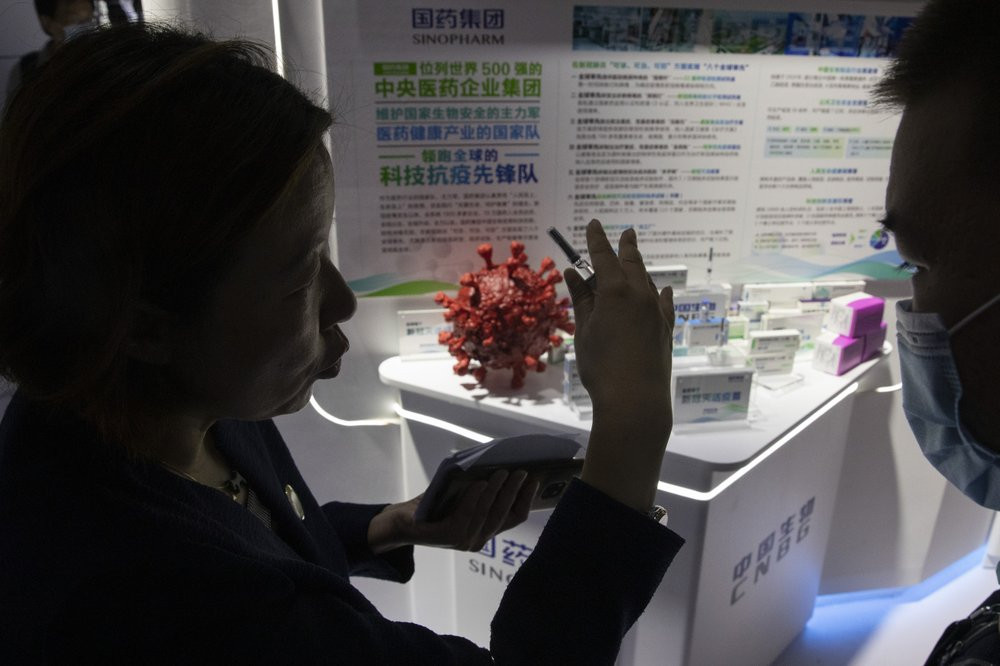 A promoter talks about the COVID-19 vaccine produced by Sinopharm subsidiary CNBG during a trade fair in Beijing on Sunday, Sept. 6, 2020.