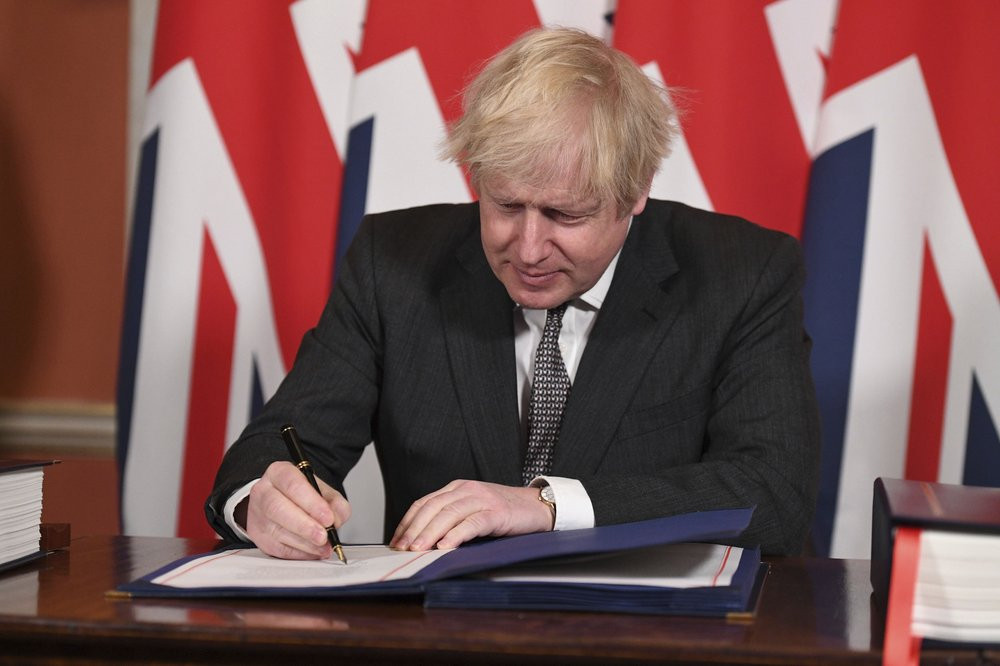 Britain's Prime Minister Boris Johnson signs the EU-UK Trade and Cooperation Agreement at 10 Downing Street, London Wednesday Dec. 30, 2020.