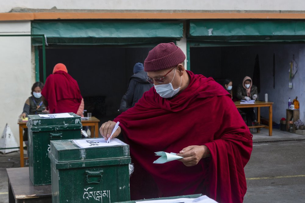 An exile Tibetan Buddhist monk wearing a mask as a precaution against the coronavirus casts his ballot in Dharmsala, India, Sunday, Jan. 3, 2021.