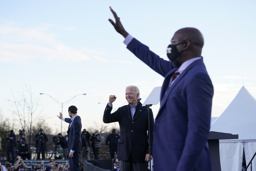 US President-elect Joe Biden campaigns in Atlanta, Monday, Jan. 4, 2021, for Senate candidates Raphael Warnock, right, and Jon Ossoff, left.