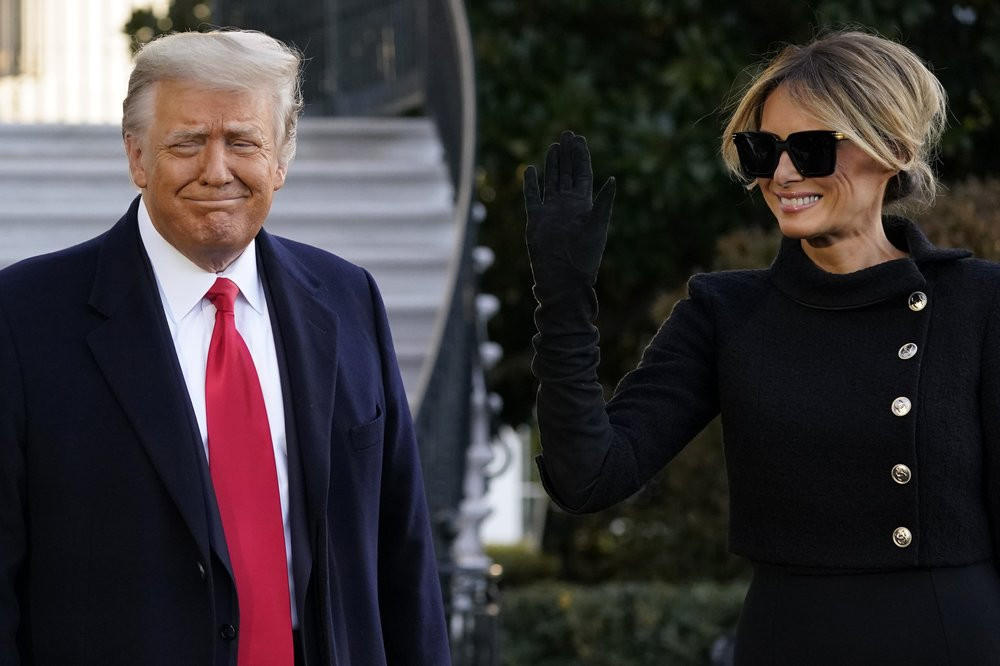 US President Donald Trump and first lady Melania Trump stop to talk with the media as they walk to board Marine One on the South Lawn of the White House, Wednesday, Jan. 20, 2021, in Washingt