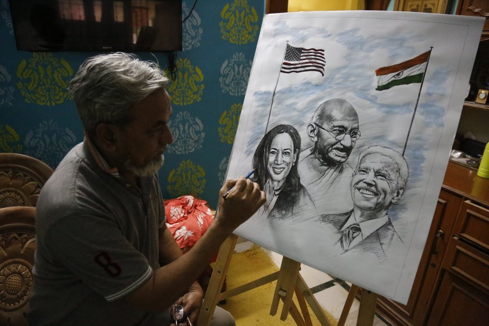 An Indian artist Aejaz Saiyed gives finishing touch to an art work featuring U.S.President-elect Joe Biden, Vice President-elect Kamala Harris and Indian freedom fighter Mahatma Gandhi, ahead