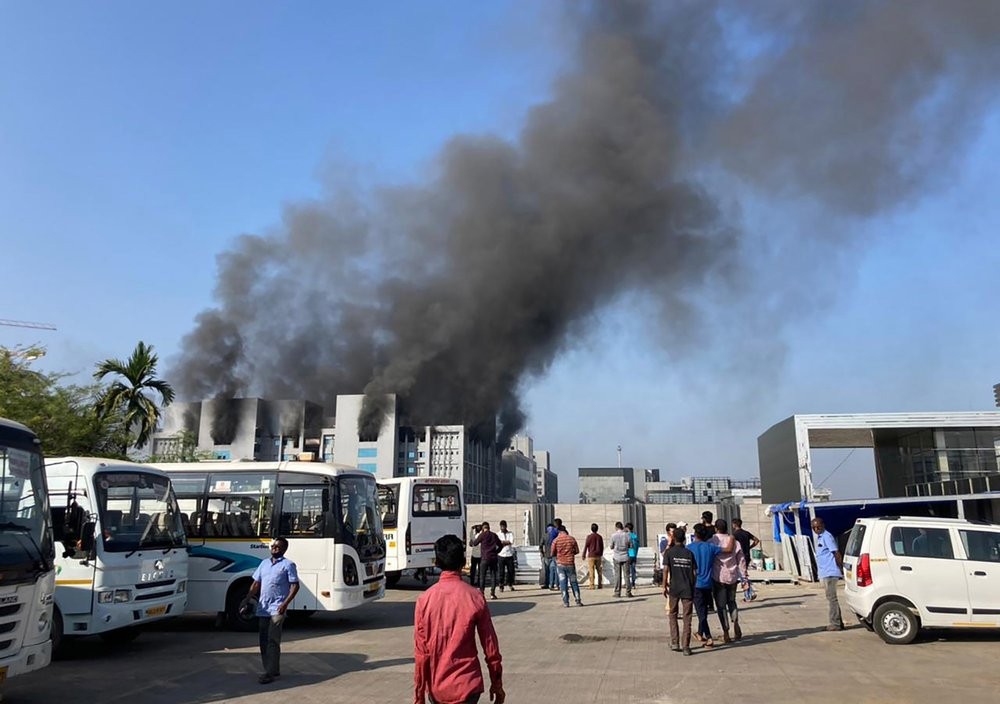 Smoke rises from the Serum Institute of India, the world's largest vaccine maker that is manufacturing the AstraZeneca/Oxford University vaccine for the coronavirus, in Pune, India, Thursday,