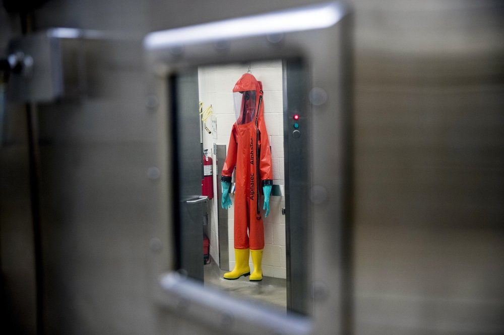 In this March 19, 2020, file photo, a biosafety protective suit for handling viral diseases are hung up in a biosafety level 4 training facility at U.S. Army Medical Research and Development 