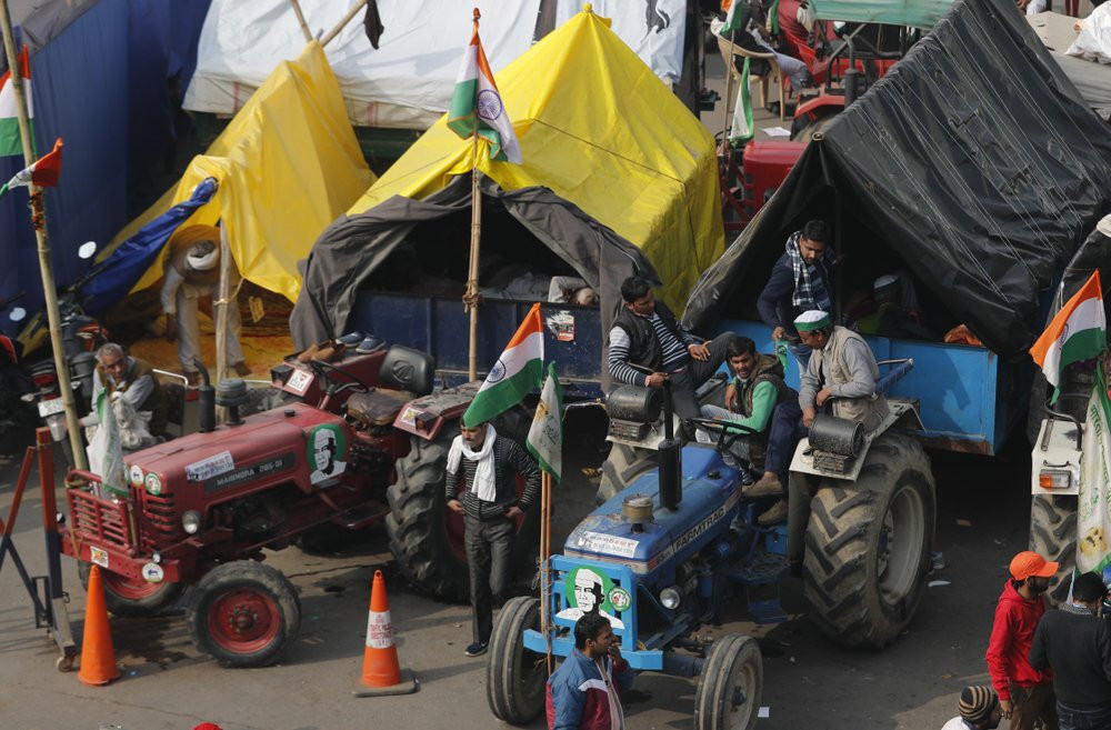 Indian farmers sit on their tractor after arriving at the Delhi-Uttar Pradesh border for Tuesday's tractor rally in New Delhi, India, Monday, Jan. 25, 2021.