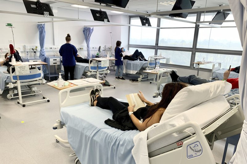 In this Tuesday, May 26, 2020 photo released by Nucleus Network/ABC, clinical trial participants are monitored during Novavax COVID-19 vaccine testing in Melbourne, Australia.