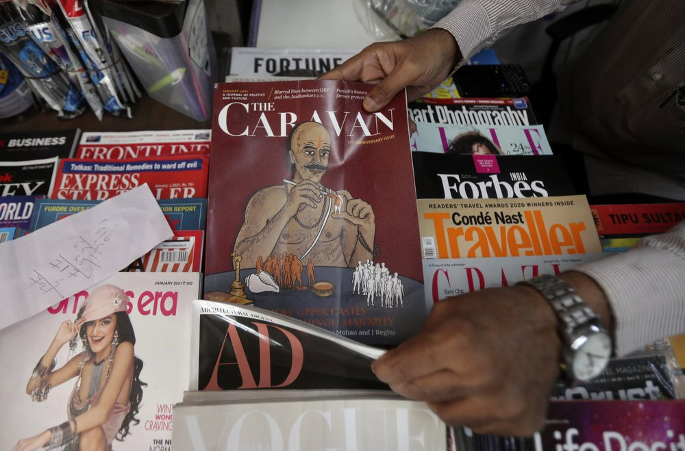 A vendor reaches out for a copy of The Caravan, India’s leading investigating magazine, in Mumbai, India, Friday, Feb. 5, 2021.