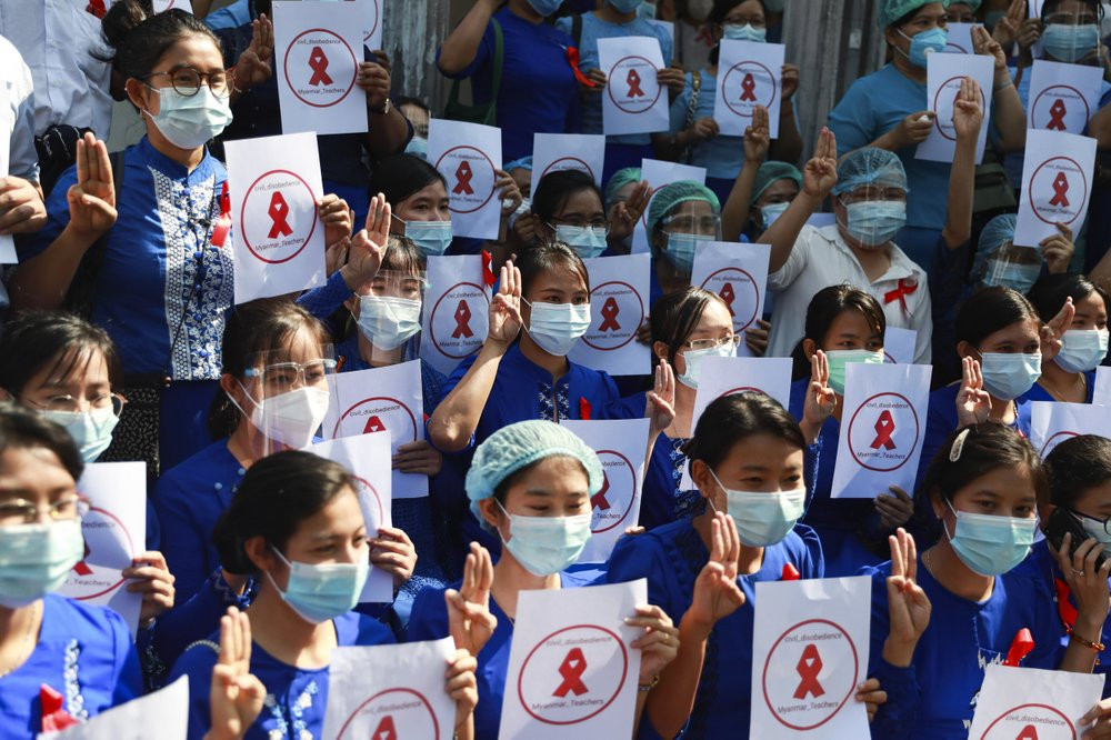 Teachers from the Yangon Education University hold signs during a civil disobedience gathering in Yangon, Myanmar Friday, Feb. 5, 2021.
