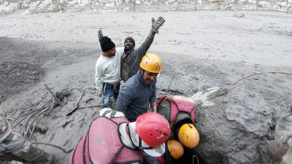 This photograph provided by Indo Tibetan Border Police (ITBP) shows a man reacting after he was pulled out from beneath the ground by ITBP personnel during rescue operations after a portion o