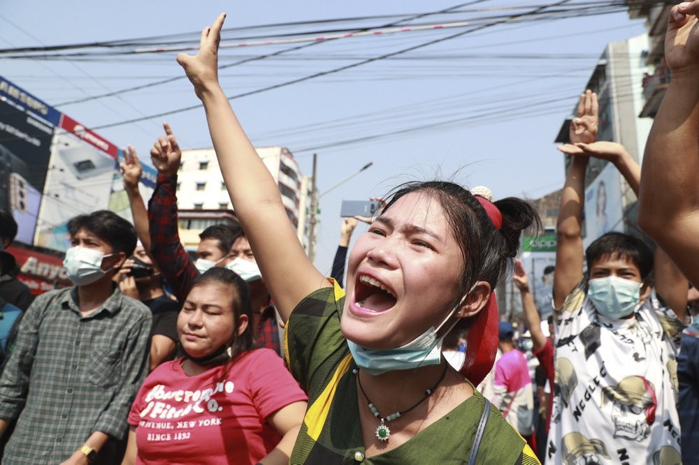 A protester shouts as she flashes the three-fingered salute during a protest rally in Yangon, Myanmar, on Feb. 6, 2021.